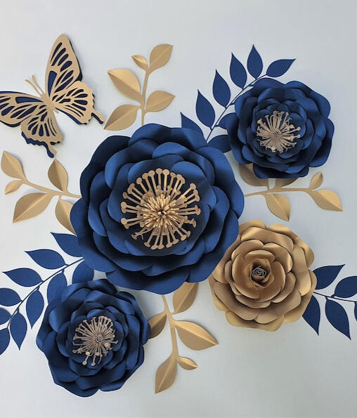 Handcrafted paper floral set with one large 24cm rose, four 15cm medium, and five 10cm small navy blue flowers, accented with 16 gold leaves, ideal for adding a touch of elegance to any sophisticated event or home space.